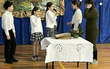 Na zdjęciu widzimy uczni&oacute;w naszej szkoły kt&oacute;rzy biorą udział w spektaklu "Jasełka:" Uczniowie ubrani są w odświętne stroje, a cała społeczność szkolna w świątecznym nastroju