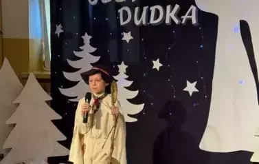 Uczennica śpiewa piosenkę w tle zimowa dekoracja