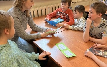 Uczniowie ze świetlicy szkolnej podczas zajęcia w bibliotece  "Z książką i kredką"