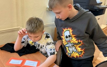 Uczniowie ze świetlicy szkolnej podczas zajęcia w bibliotece  "Z książką i kredką"