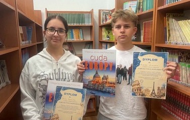 Uczniowie pozują do zdjecia z dyplomami i nagrodami