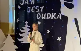 Uczennica śpiewa piosenkę w tle zimowa dekoracja