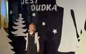 Uczennica śpiewa piosenkę w tle zimowa dekoracja