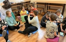 Uczniowie ze świetlicy szkolnej podczas zajęcia w bibliotece  "Z książką i kredką"
