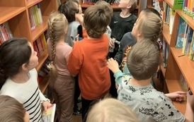 Uczniowie ze świetlicy szkolnej podczas zajęcia w bibliotece  "Z książką i kredką"