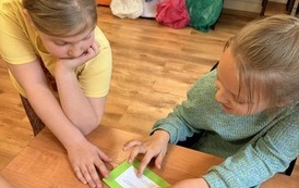 Uczniowie ze świetlicy szkolnej podczas zajęcia w bibliotece  "Z książką i kredką"