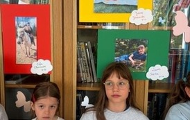 Uczniowie pozują do zdjęcia ze swoimi pracami fotograficznymi.