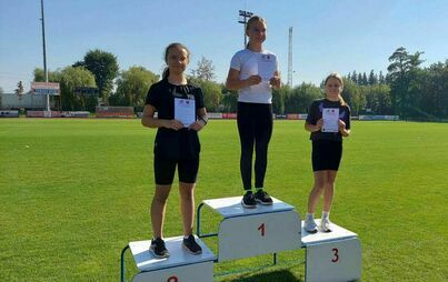 Zdęcia przedstawiają uczniów na podium, którzy brali udział w zawodach lekkoatletycznych. Uczniowie pozują do zdjęcia na boisku szkolnym.