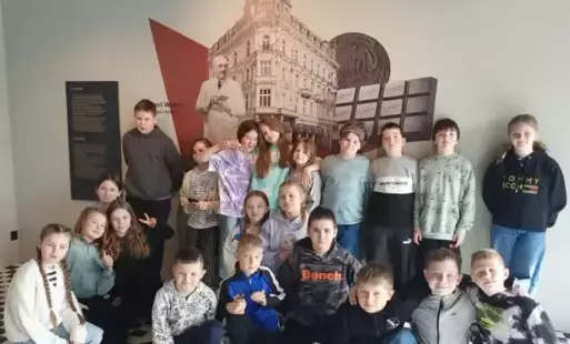 Uczniowie pozują do zdjęcia  na tle scianki E. Wedla