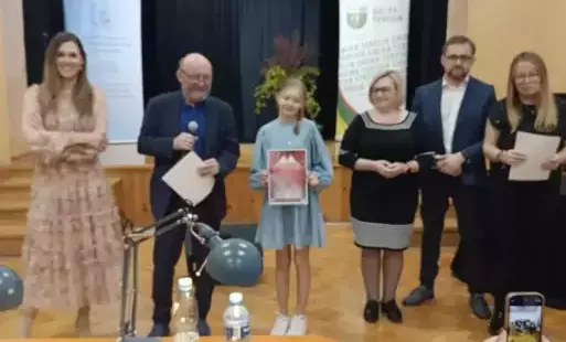 Na zdjęciu widzimy uczennice, która otrzymała wyróżnienie w konkursie powiatowym wraz z jurorami konkursy