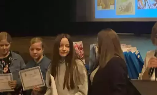 Na zdjęciu widzimy uśmiechniętą  uczennicę w ręku trzyma dyplom.