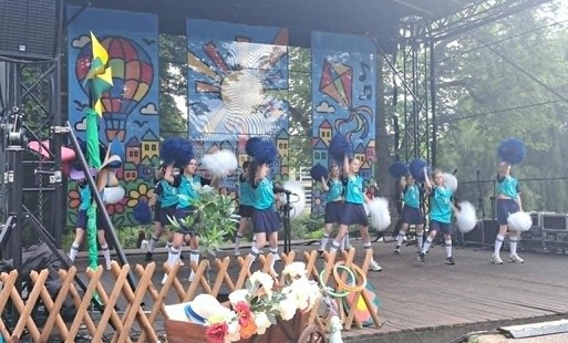 Na zdjęciu widzimy, zespół cheerleaderek, podczas Dnia Dziecka na letniej scenie.