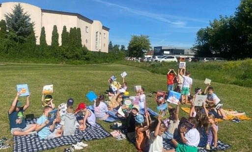 Uczniowie podczas zajęć na świeżym powietrzu " Czytanie na polanie"